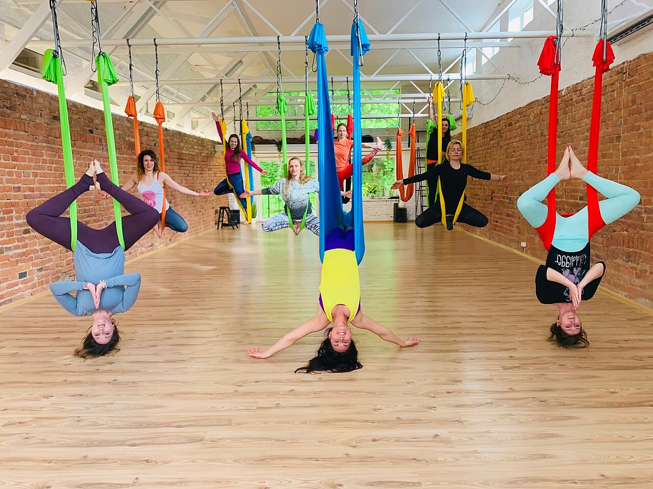 Groep beoefent aerial yoga in hangende doeken